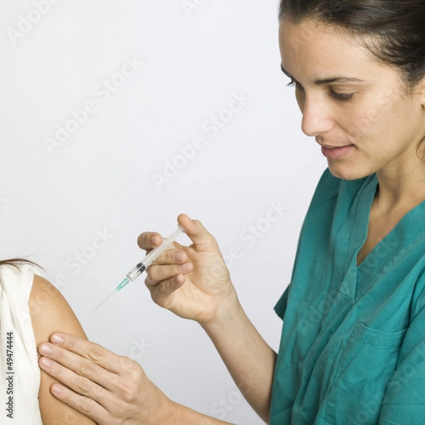 Obraz Junge Krankenschwester impft eine Patientin