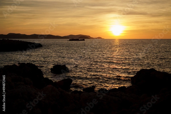 Fototapeta Cala Viola de Ponent, Menorca. September 2021. Magnificent sunset in the Mediterranean Sea. On one of the paradisaical beaches of the island of Menorca.