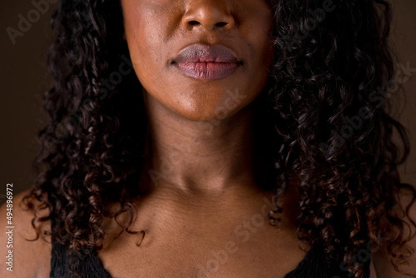 Fototapeta Close up portrait of african american woman features and soft dark caramel skin. Horizontal front view of unrecognizable woman lips and nose. People and diversity concept.