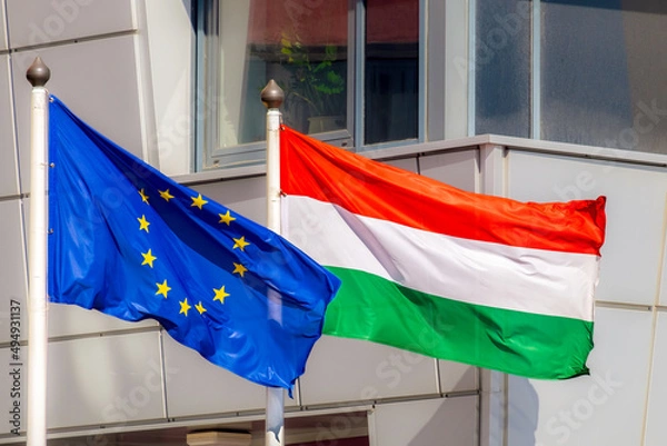 Obraz The flags of the European Union and Hungary are waving in the wind