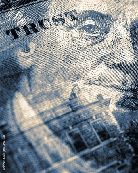 Fototapeta American paper money. 100 dollar bill with portrait of Benjamin Franklin in focus. US banknote closeup. Blue tinted vertical stories about USA dollars. Bonds and treasuries. We trust phrase fragment
