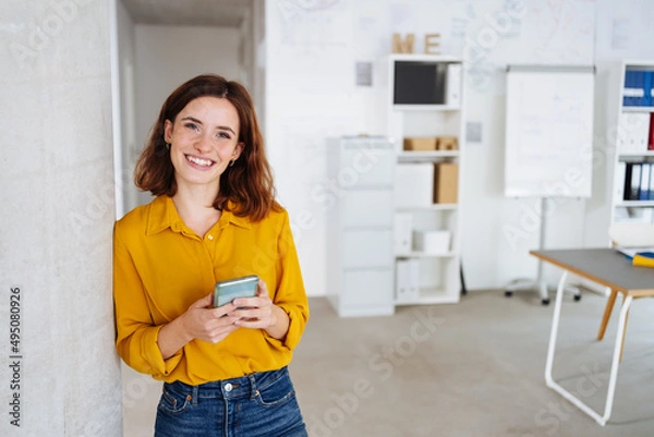Obraz young modern business woman with cell phone laughs at camera