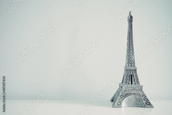 Fototapeta Eiffel tower model on white wall background copy space. Travel in Europe concept.