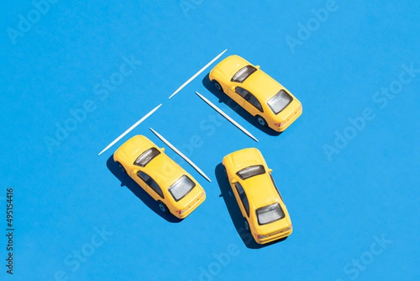 Obraz Creative car and transportation idea with yellow cars on vivid blue background. Graphic traffic and parking idea, minimal visual composition.