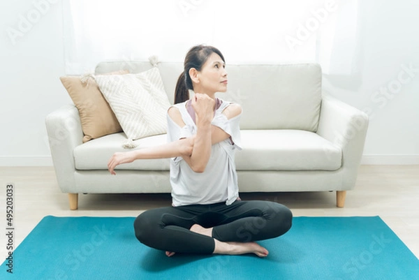 Fototapeta 部屋でヨガをするミドル世代の女性
