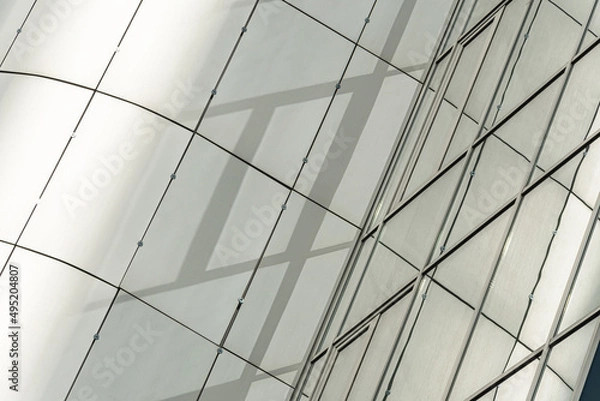 Fototapeta Geometric colored building facade elements with planes, lines and corners with light flare and reflections for an abstract background and texture of white, blue, gray colors. Place for text