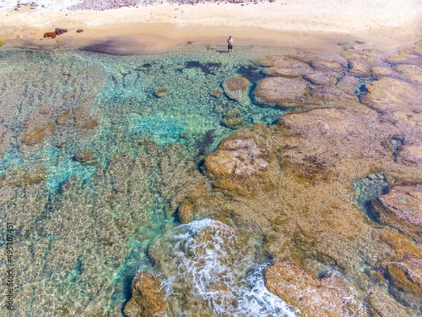 Fototapeta Aerial view of a man alone at the beach in spring