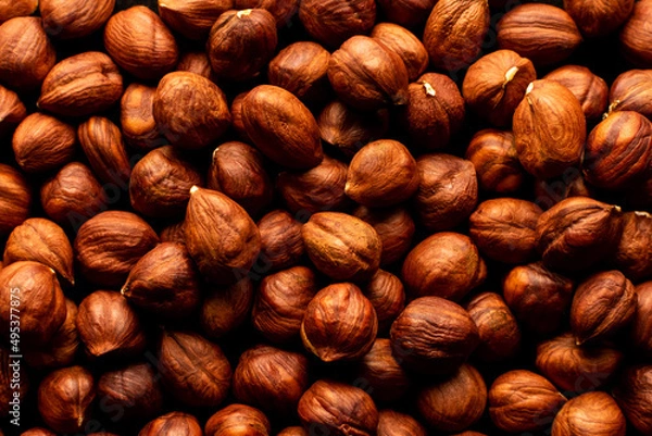 Fototapeta Peeled hazelnuts on a white wooden background. Isolate.