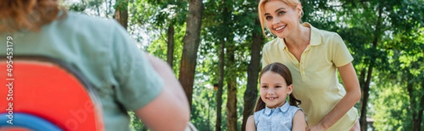 Fototapeta happy mother and daughter looking at boy on blurred foreground, banner.