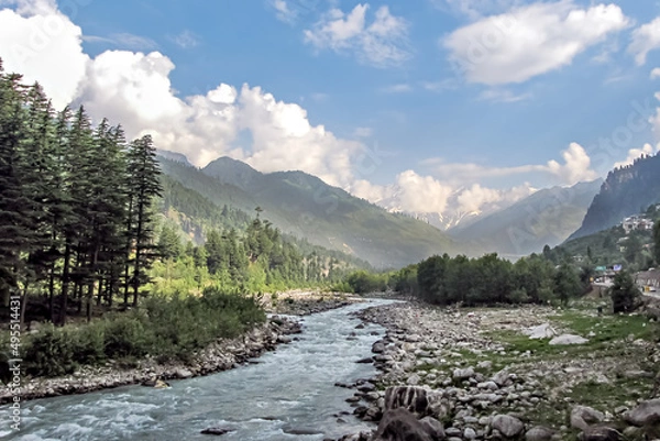 Obraz Beas river with snow cladded mountain , blue clouds and greenery in the background.