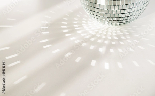 Obraz Disco ball on a white background with shadows and casts rays of bright light. Glare and light reflection effect. Copy space.