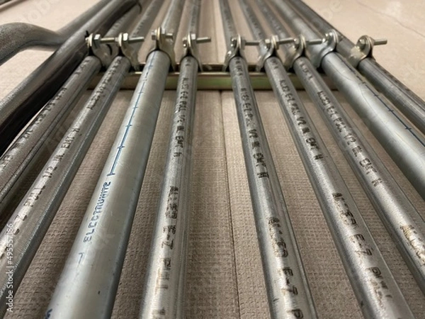 Fototapeta Electrical conduit for cable routing. Electrical metallic tubing in the building. Bending electrical conduits. Pipes of power lines and signal cables.