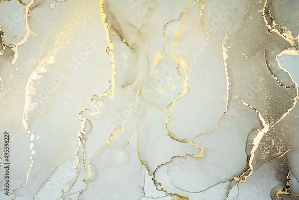 Fototapeta Luxury abstract fluid art painting in alcohol ink technique, mixture of pastel gray and gold paints. Imitation of marble stone cut, glowing golden veins. Tender and dreamy design.