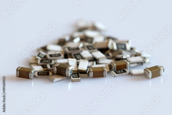 Fototapeta SMD resistors and capacitors isolated on white background. Selective focus.
