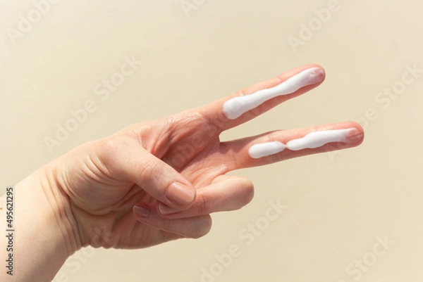 Fototapeta A person applying the correct amount of sunscreen for face and neck.