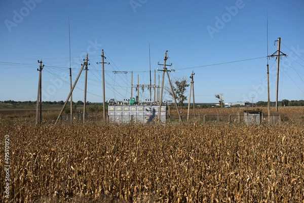 Fototapeta Transformers - electrical substation on an agricultural field.