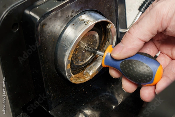 Fototapeta Man fixes old coffee machine.