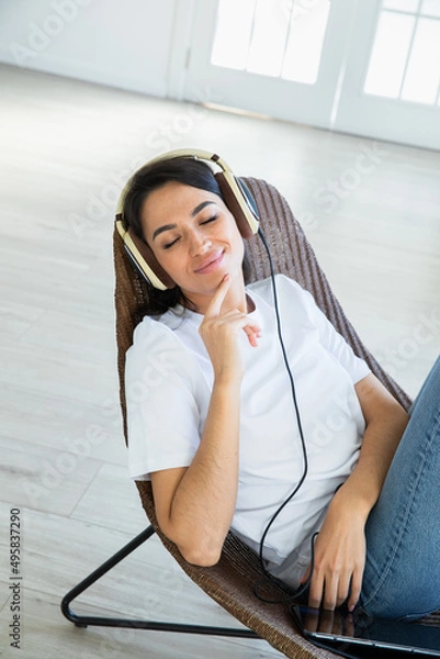 Obraz Happy woman with teadphones sitting at chear  at home