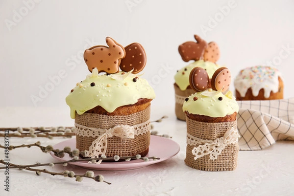 Fototapeta Delicious Easter cakes decorated with cookies and willow branches on light background