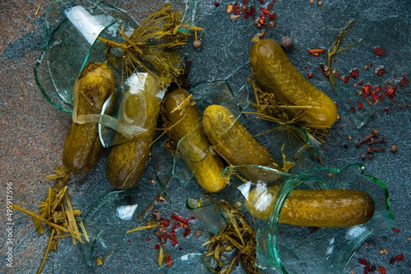 Obraz Pickled cucumbers in a broken jar