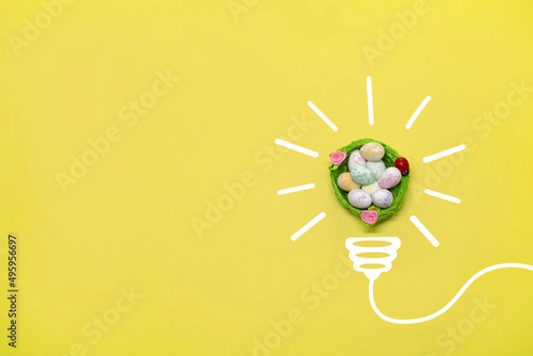 Fototapeta Idea symbol in the form of a painted light bulb with decorative Easter basket with eggs inside on a yellow background. Easter time
