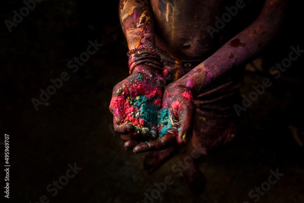 Fototapeta Close-up of the hands of a girl who holds colorful paint while celebrating the festival of color