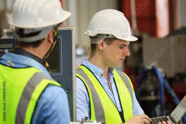 Fototapeta Caucasian industrial engineer worker working in a factory and making a discussion together. 