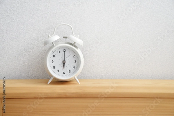Fototapeta 白い目覚まし時計　時計　置き時計　卓上　デスク　机　ベッド　朝　夕方　夜　時間　６時　余白　白背景　文字スペース　ホワイトスペース　コピースペース