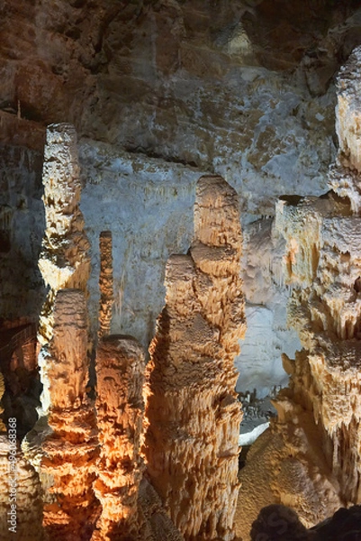 Fototapeta Frasassi Caves in Italy. Spectacular caverns in Le Marche. Close-ups of huge limestone columns. Illuminated stalactites and stalagmites under the mountains. Charm, mystery and caving. 