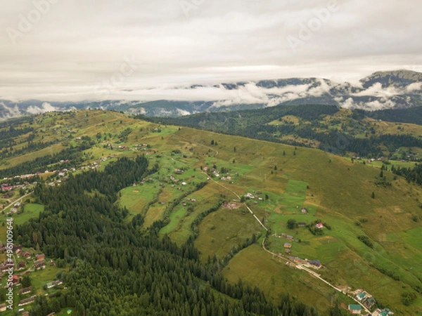 Fototapeta Green slopes of Ukrainian Carpathian mountains in summer. Cloudy morning, low clouds. Aerial drone view.
