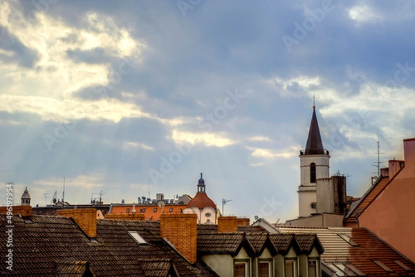 Obraz Poland, Zielona Góra 31.3.2022. Roofs of the old town of Zielona Góra. The rays of the sun shine on the tiled roofs of houses. 