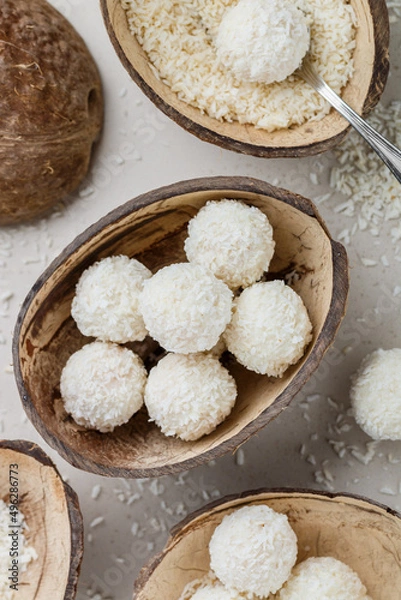 Fototapeta Homemade round candies made of coconut and white chocolate. Preparation of a delicious healthy dessert. Raffaello. Selective focus, top view