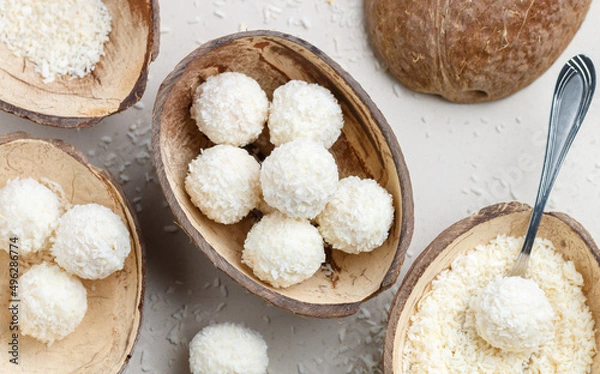 Fototapeta Homemade round candies made of coconut and white chocolate. Preparation of a delicious healthy dessert. Raffaello. Selective focus, top view