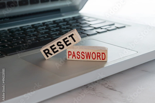 Fototapeta Reset password text on wooden block cube placed on laptop or notebook.
