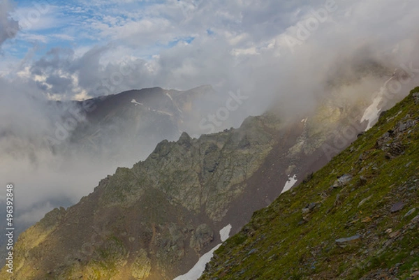 Fototapeta mountain ridge in dense mist and clouds, mountain travel background