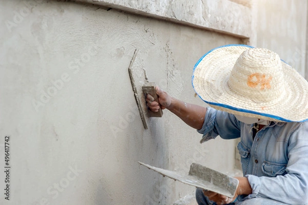 Fototapeta Plastering of plaster workers on the walls