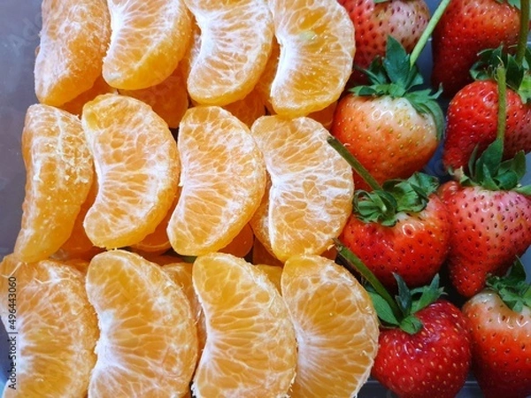 Obraz Top view of orange and strawberry fruit as a background for sale on market stand in Thailand, Fresh fruit ready to eat or making drinks and salads, Healthy concept