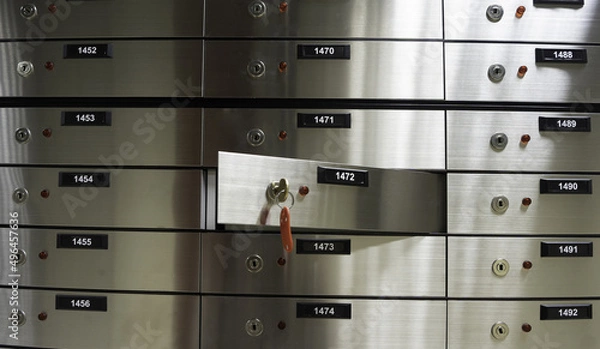Fototapeta Safe deposit boxes inside bank vault. Open deposit box with key