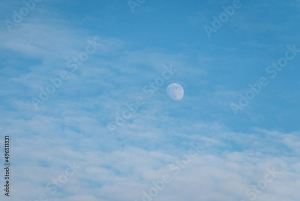 Obraz White full moon against a blue sky with clouds.