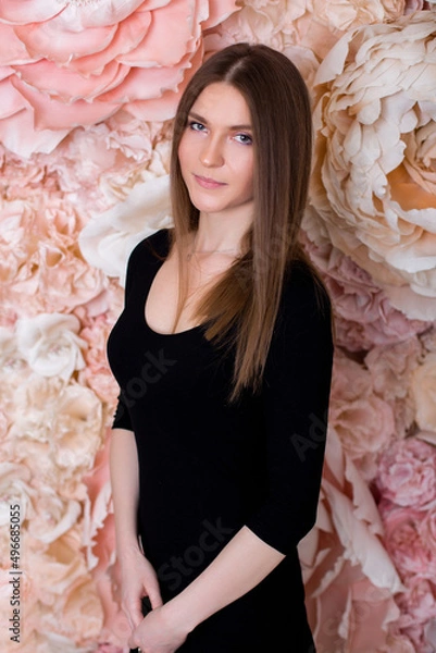 Fototapeta 
Young beautiful, stylish woman with long brunette hair on flower wall background