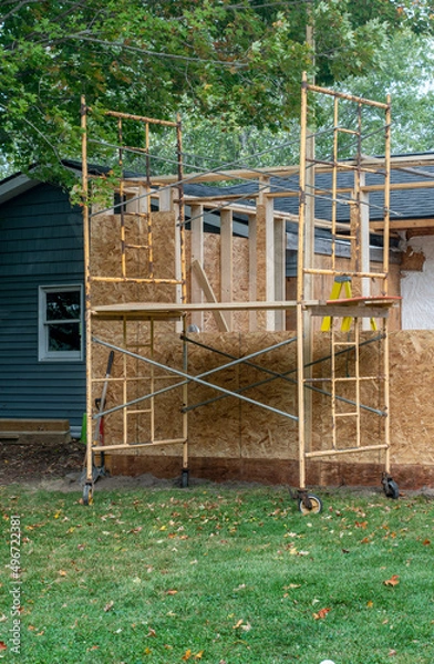 Obraz Building a room addition onto a home with scaffong set up to reach the top walls