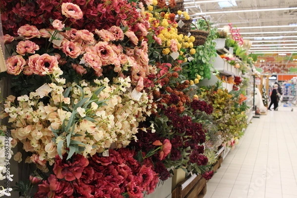 Fototapeta Russia, Novosibirsk 30.11.2021: a showcase with flowers in the greenhouse of a garden store with a buyer