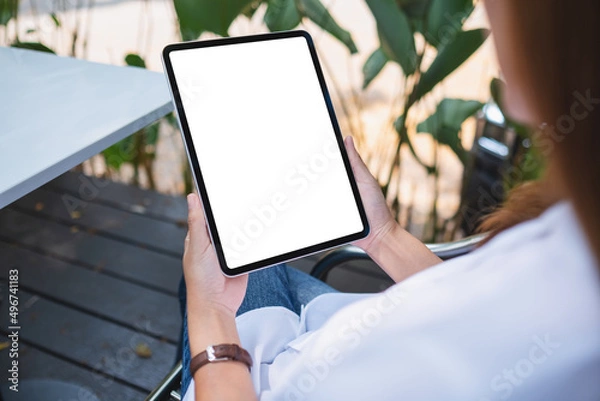 Obraz Mockup image of a woman holding digital tablet with blank white desktop screen in the outdoors