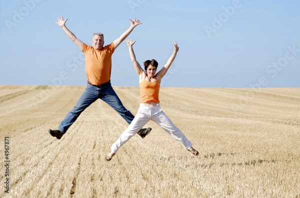 Obraz couple sautant dans un champ de blè