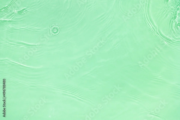 Fototapeta Transparent green clear water surface texture with ripples, splashes and bubbles. Abstract nature background Water waves in sunlight with copy space Cosmetic moisturizer micellar toner emulsion