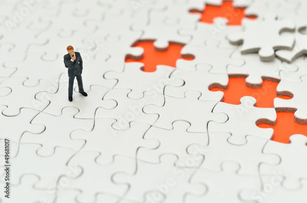 Obraz オレンジ色背景のジグソーパズルとビジネスマン