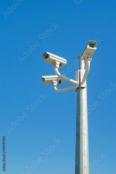 Obraz Three closed circuit television cameras against blue sky