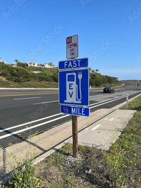 Obraz Road sign on the Pacific Coast Highway for Electric Vehicle fast charging station in Southern California.