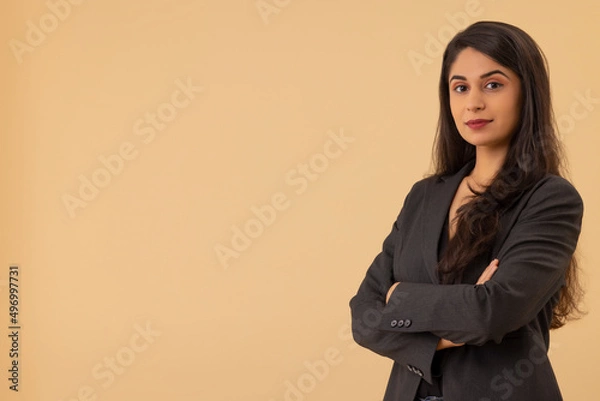 Fototapeta Portrait of a young businesswoman looking at the camera with arms crossed