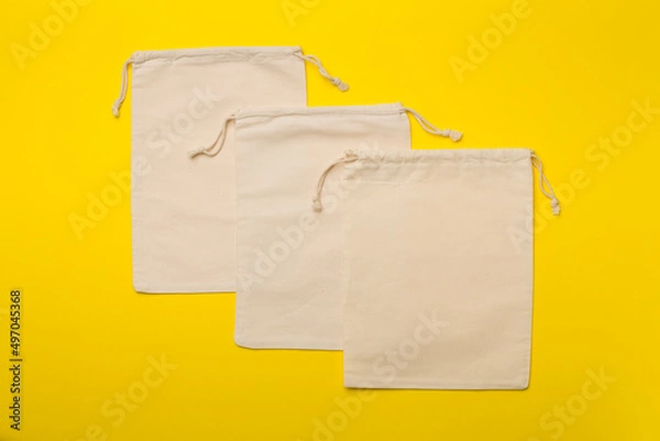 Fototapeta Small eco sacks on color background. Top view